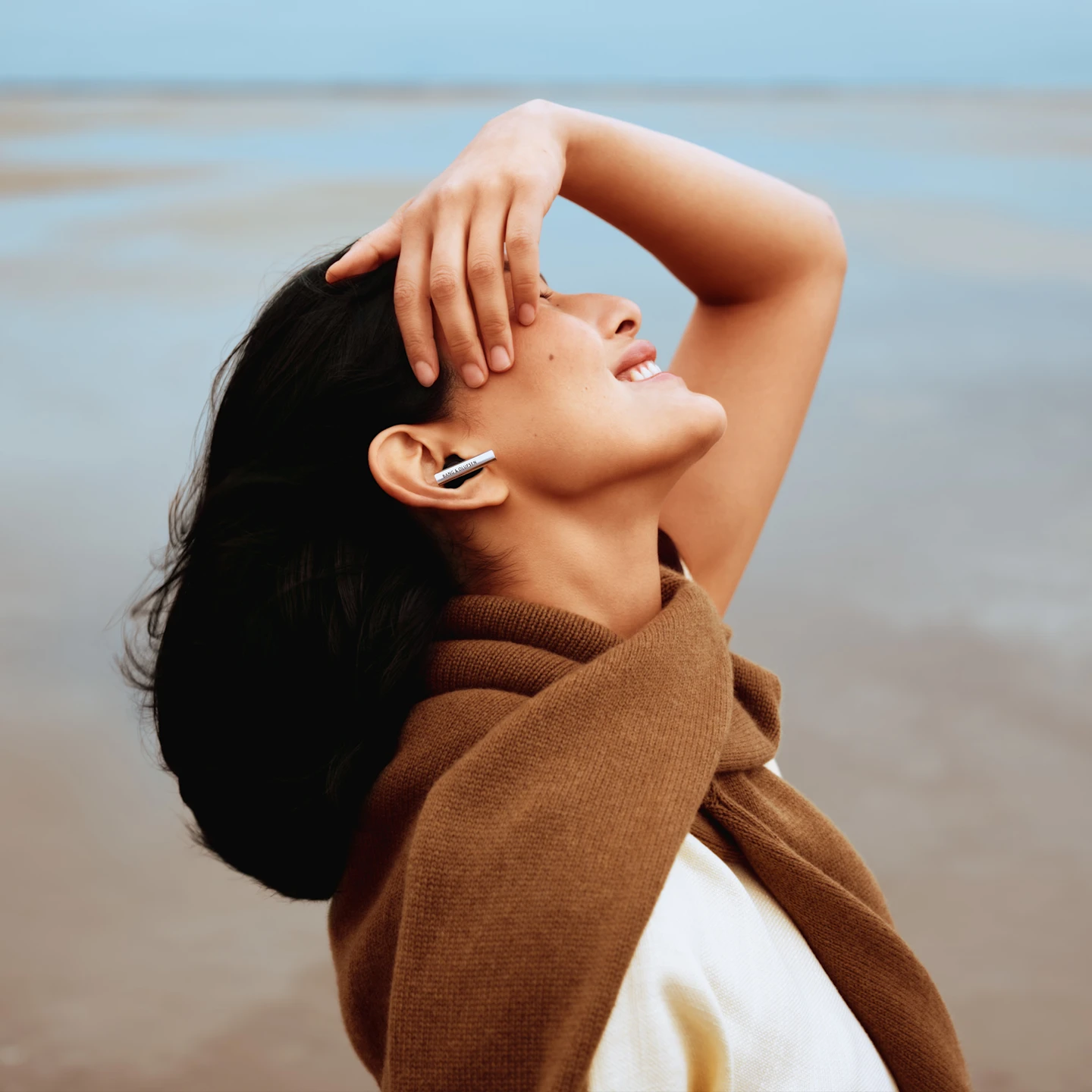 Side face of a woman smiling who's wearing Super Hoodie and feeling the music